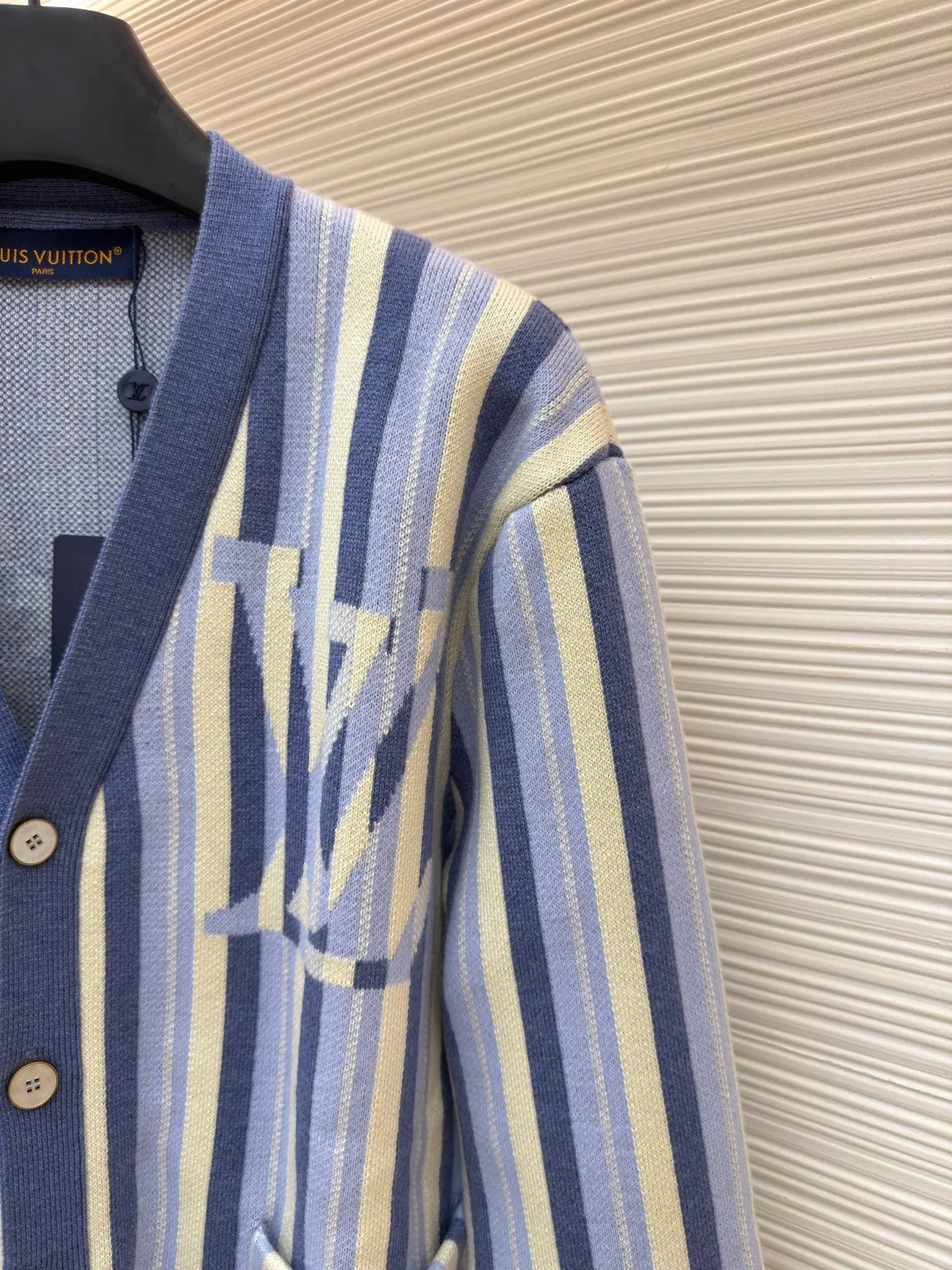 LOUIS VUITTON striped jacquard single-breasted sweater ●Original version: Purchased and developed for 15100 ●Item number: 1682314-C00 ●Fabric: wool fabric ●Technology: jacquard knitting ●Color: blue ●Version: fitted version ●Weight: about 930 grams ●Size: S-M-L-XL ●Description: This LV striped knitted cardigan is made of high-count worsted wool blended yarn. The double-ply threading process enhances the yarn's toughness. It is not easy to pill and has an outstanding drape feeling. The body of the garment adopts vertical jacquard weaving technology, with navy blue, light blue and off-white yarns interlaced with each other. The stripe width and spacing are precisely controlled by a computerized flat knitting machine, so that the color transition is natural and even. The LV letter jacquard on the left body has been debugged several times through plate making to ensure that the pattern is three-dimensional and clear. The V-neck, cuffs, and hem all use ribbing technology and are pre-shrunk to shape, making them less likely to loosen and deform after long-term wear. The buttons are made of custom-made metal, with matte sandblasting on the surface, and are hand-stitched with the seams of the body. The pockets use welting technology, and the edges are flat without jumpers. Every detail reflects the exquisite clothing craftsmanship and brand ingenuity. The overall wiring is straight and delicate, the fabric is comfortable and soft, and the color is consistent without color difference. It can be matched with the same style to create a fashionable look and control various occasions. Customized accessories, complete with three standards, same style for men and women!